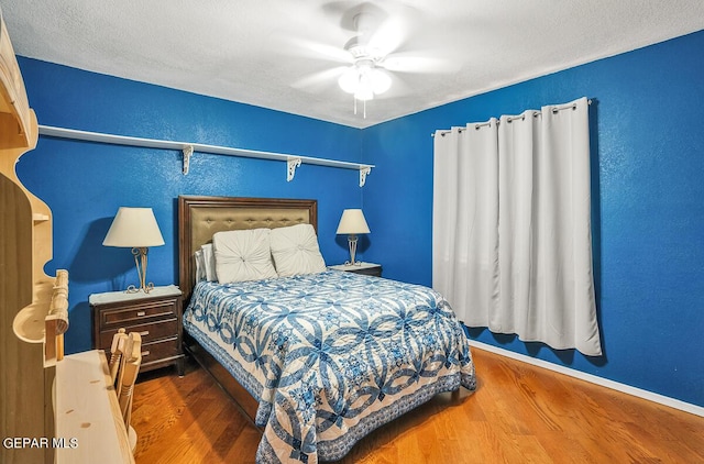 bedroom featuring a textured ceiling, dark wood-type flooring, and ceiling fan