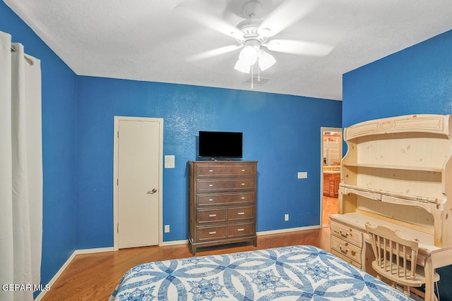 bedroom featuring hardwood / wood-style floors, a textured ceiling, and ceiling fan