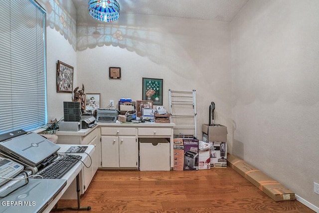 home office featuring light hardwood / wood-style flooring and a textured ceiling