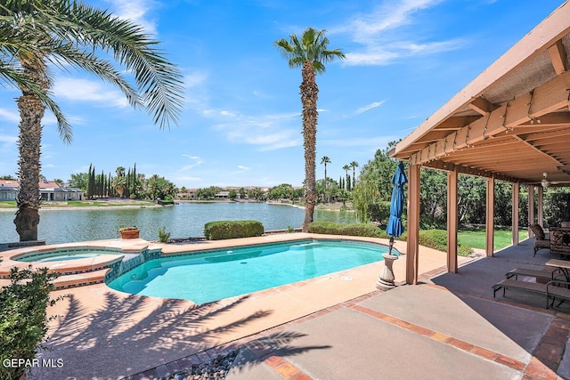 view of pool with an in ground hot tub, a water view, and a patio