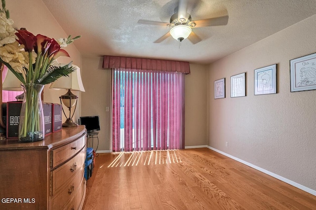 bedroom featuring ceiling fan, a textured ceiling, and light hardwood / wood-style floors