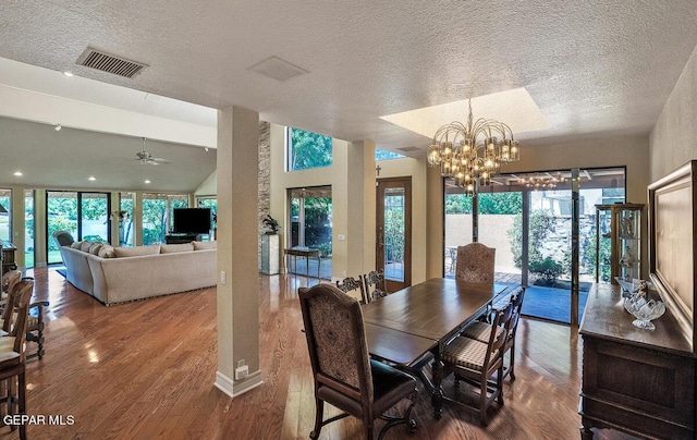 dining space with hardwood / wood-style floors, ceiling fan with notable chandelier, and a textured ceiling