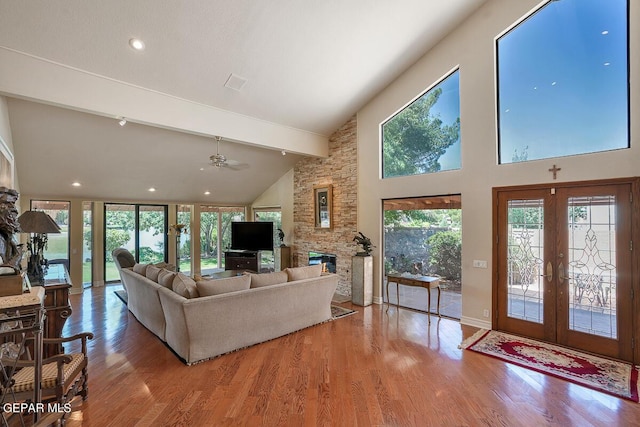 living room with french doors, high vaulted ceiling, beamed ceiling, a fireplace, and hardwood / wood-style floors