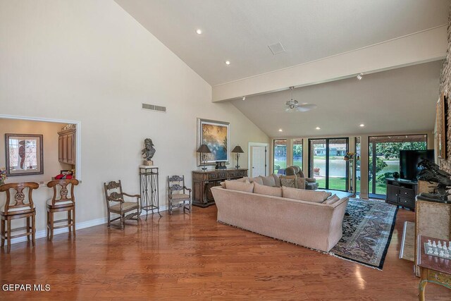 living room featuring hardwood / wood-style flooring, ceiling fan, high vaulted ceiling, and beam ceiling