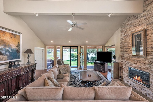 living room with hardwood / wood-style flooring, ceiling fan, a fireplace, and vaulted ceiling with beams