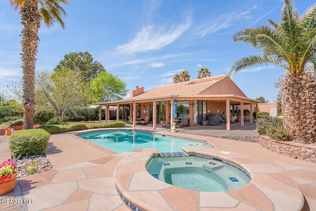 view of swimming pool featuring an in ground hot tub and a patio