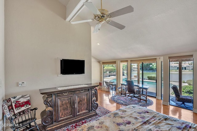 living room featuring lofted ceiling, a wealth of natural light, a textured ceiling, and light hardwood / wood-style flooring