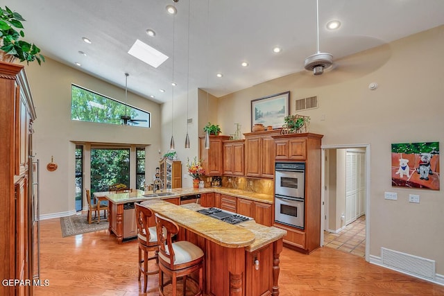 kitchen featuring appliances with stainless steel finishes, a center island, a breakfast bar area, and kitchen peninsula