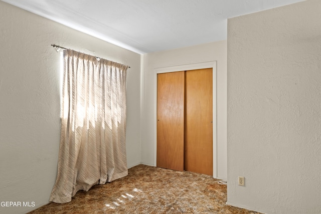 unfurnished bedroom with carpet and a closet