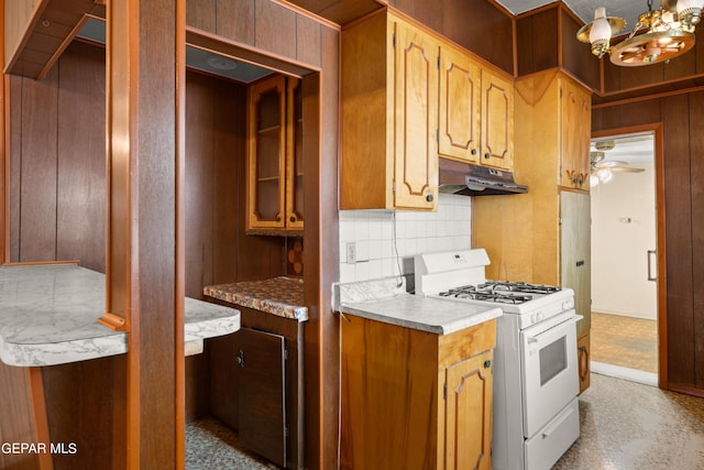 kitchen featuring tasteful backsplash, ceiling fan with notable chandelier, and white gas range oven