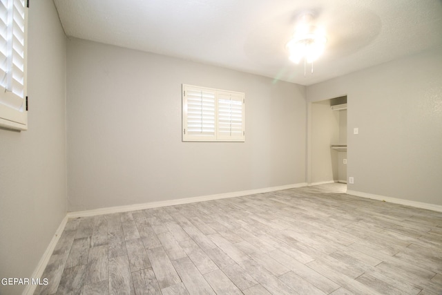 empty room featuring light wood-type flooring and ceiling fan