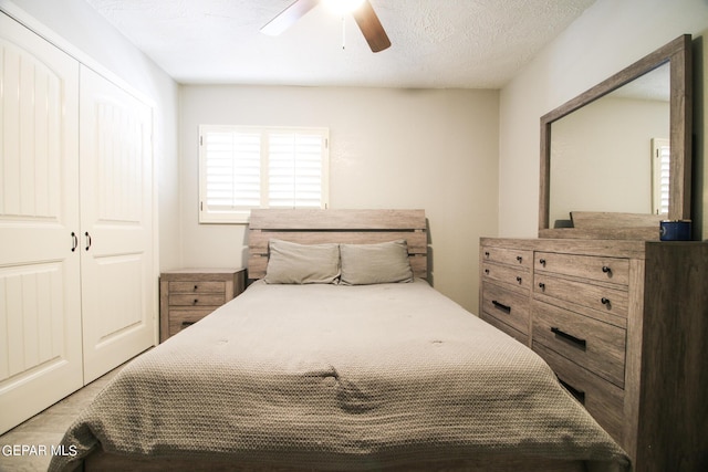 bedroom featuring a textured ceiling, ceiling fan, and a closet