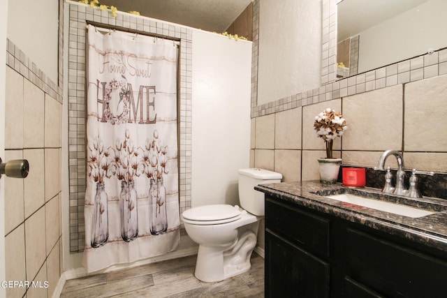 bathroom featuring curtained shower, tile walls, tasteful backsplash, toilet, and vanity