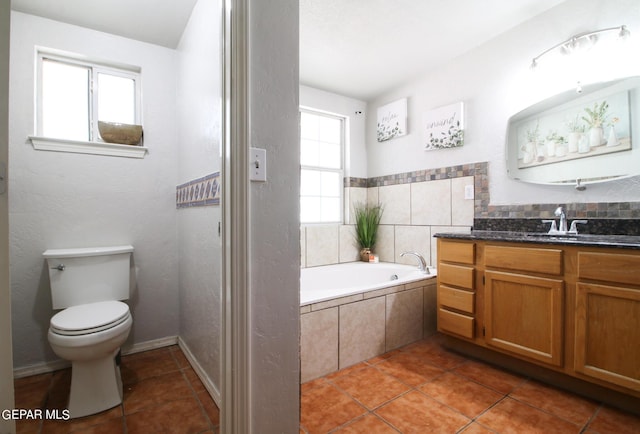 bathroom featuring vanity, tile patterned flooring, tiled bath, and toilet