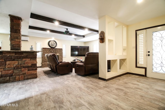 living room with ceiling fan, beam ceiling, a wall mounted air conditioner, and light hardwood / wood-style flooring