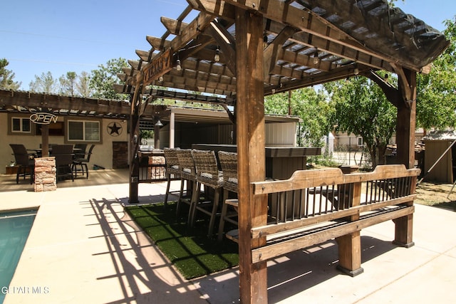 view of patio featuring a bar and a pergola