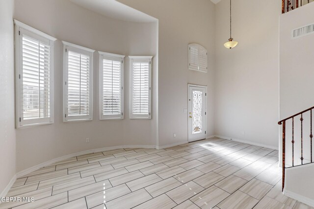 foyer with light tile patterned floors and a towering ceiling