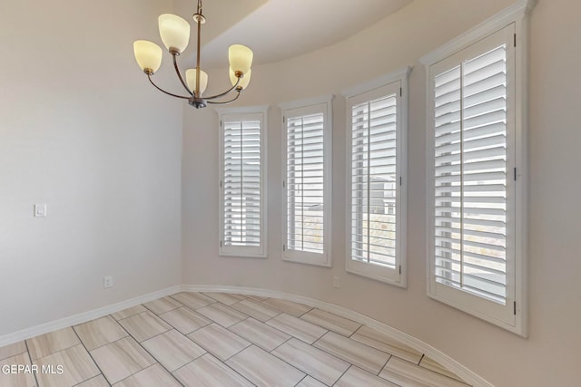 empty room featuring a notable chandelier and light tile patterned floors