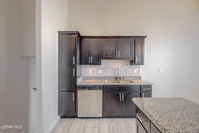 kitchen featuring sink, dishwasher, light stone counters, and tasteful backsplash