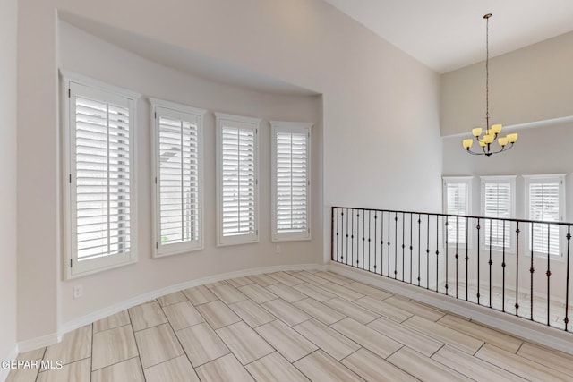 unfurnished room with an inviting chandelier, light hardwood / wood-style flooring, and plenty of natural light