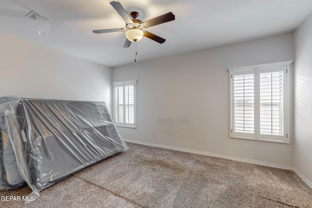 unfurnished bedroom featuring multiple windows, ceiling fan, and light colored carpet