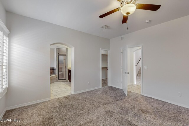 carpeted spare room featuring a healthy amount of sunlight and ceiling fan