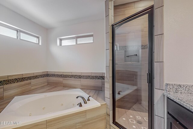 bathroom with vanity and shower with separate bathtub