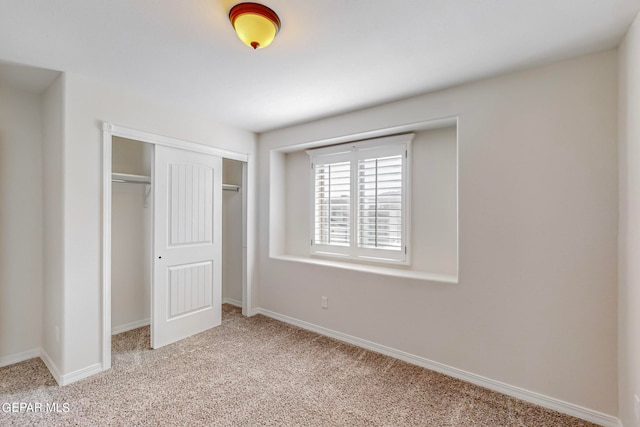 unfurnished bedroom featuring a closet and light colored carpet