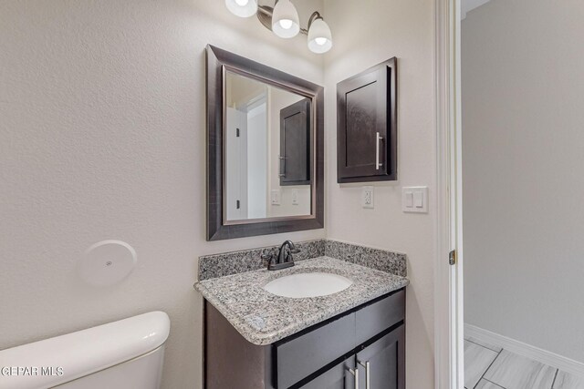 bathroom with vanity, tile patterned floors, and toilet