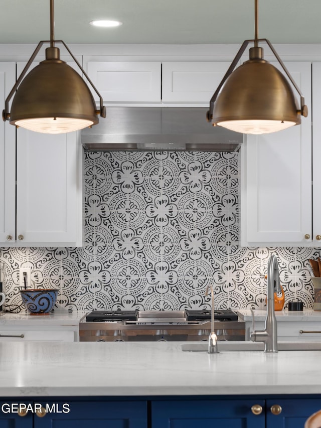 kitchen with white cabinets, tasteful backsplash, and blue cabinets