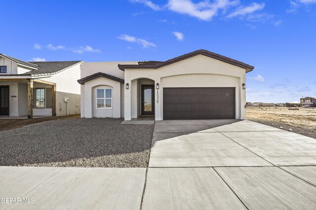 view of front facade featuring an attached garage, driveway, and stucco siding