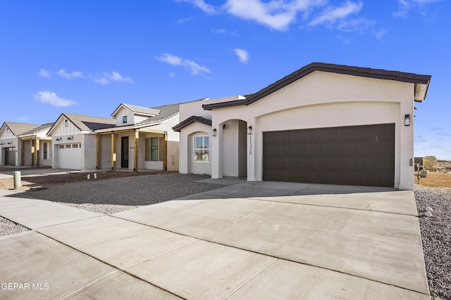 view of front of property featuring a garage, stucco siding, driveway, and a tiled roof