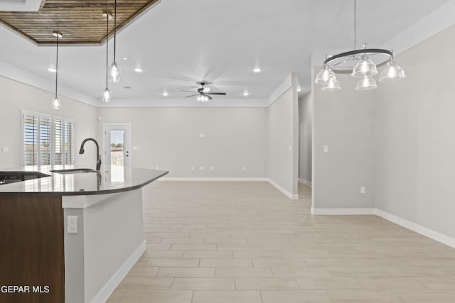 kitchen featuring baseboards, ceiling fan, recessed lighting, a sink, and decorative light fixtures