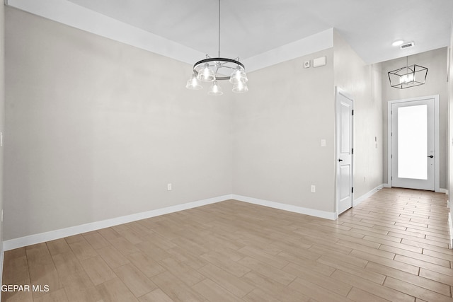 interior space featuring a high ceiling, light wood-type flooring, and an inviting chandelier