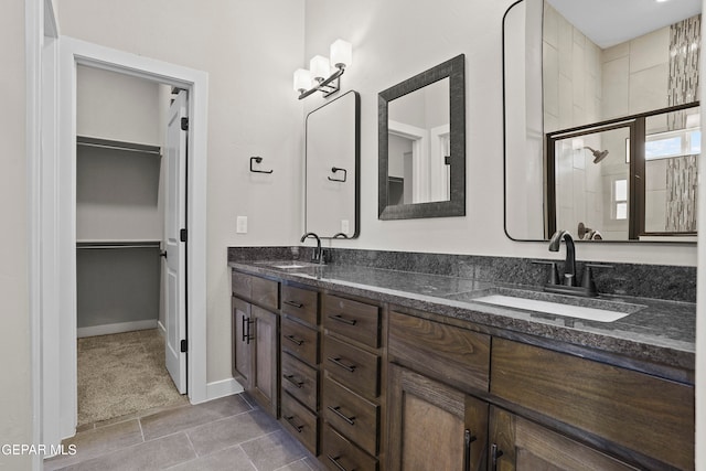 bathroom featuring a shower with shower door, vanity, and tile patterned floors