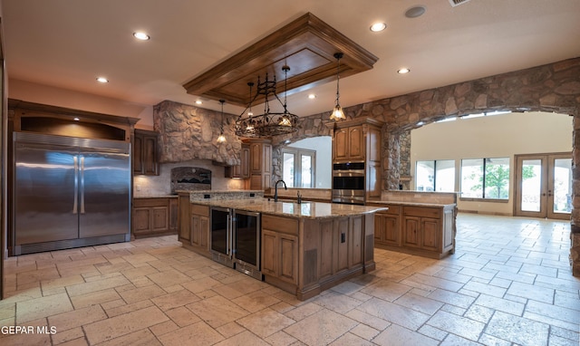 878 Cortona Pl, El Paso, TX 79928 - kitchen featuring an island with sink, wine cooler, hanging light fixtures, stainless steel built in fridge, and french doors