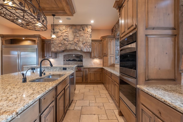 878 Cortona Pl, El Paso, TX 79928 - kitchen with sink, hanging light fixtures, stainless steel appliances, light stone countertops, and decorative backsplash