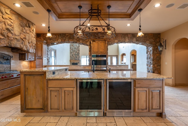 878 Cortona Pl, El Paso, TX 79928 - kitchen featuring a large island with sink, wine cooler, and a tray ceiling