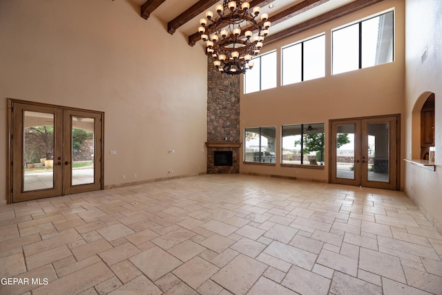 878 Cortona Pl, El Paso, TX 79928 - unfurnished living room with a high ceiling, a wealth of natural light, beam ceiling, and french doors