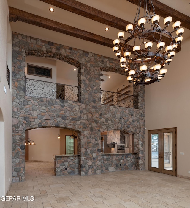 878 Cortona Pl, El Paso, TX 79928 - unfurnished living room with a notable chandelier, beam ceiling, french doors, and a high ceiling