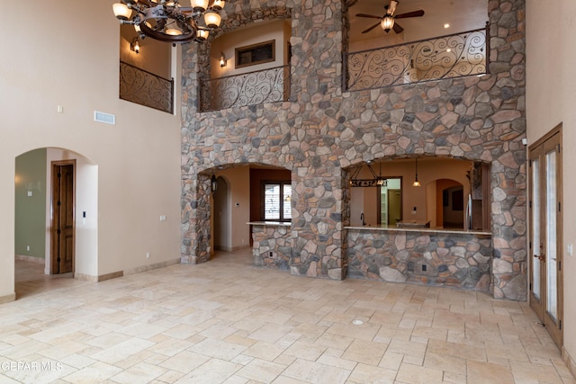 878 Cortona Pl, El Paso, TX 79928 - unfurnished living room featuring ceiling fan with notable chandelier and a high ceiling