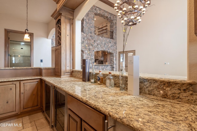 878 Cortona Pl, El Paso, TX 79928 - kitchen featuring light stone counters, beverage cooler, a stone fireplace, and pendant lighting