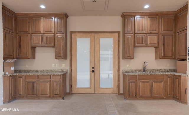 878 Cortona Pl, El Paso, TX 79928 - kitchen with light stone counters, sink, and french doors