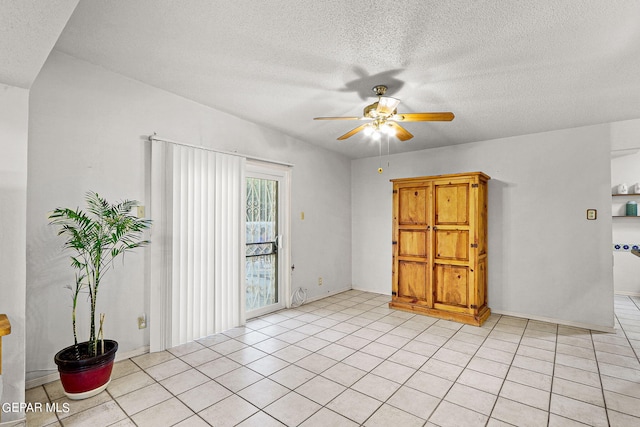 tiled empty room featuring a textured ceiling and ceiling fan