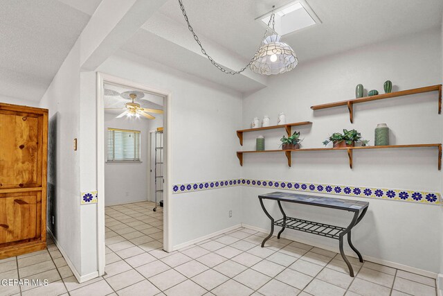 interior space featuring a skylight, light tile patterned flooring, and a textured ceiling