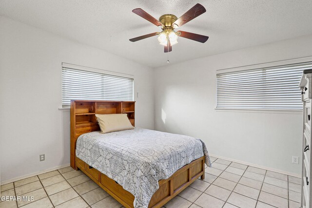 tiled bedroom featuring a textured ceiling and ceiling fan