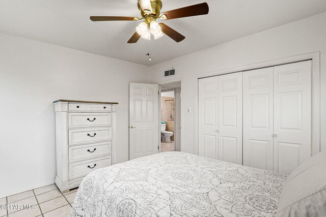 bedroom featuring a closet, light tile patterned floors, and ceiling fan