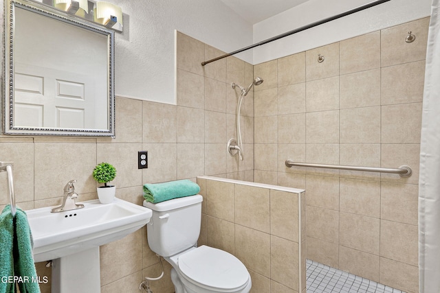 bathroom with decorative backsplash, tile walls, toilet, and a tile shower