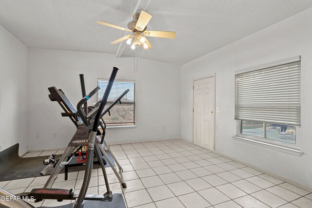 workout room with a textured ceiling, ceiling fan, and light tile patterned floors