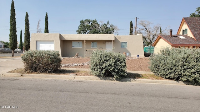 view of front of property with concrete driveway, an attached garage, and stucco siding